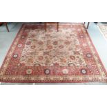 A cream ground Axminster style carpet with all-over flower head design and red and cream floral