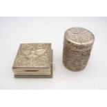 Two Thai white metal boxes, both with embossed decoration of deities amongst flames, the cylindrical