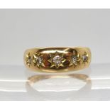 A bright yellow metal ring set with five star set diamonds, with an estimated approx diamond total