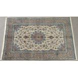 A CREAM GROUND MESHED RUG with multicolour flower head central medallion, matching spandrels and