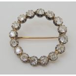 A DIAMOND CIRCLE BROOCH set with estimated approx 3ct of old cut diamonds, in cut back white metal