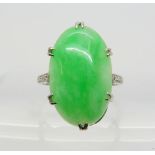 A CHINESE GREEN HARDSTONE RING the platinum handmade ring has a pretty scrolled gallery and three