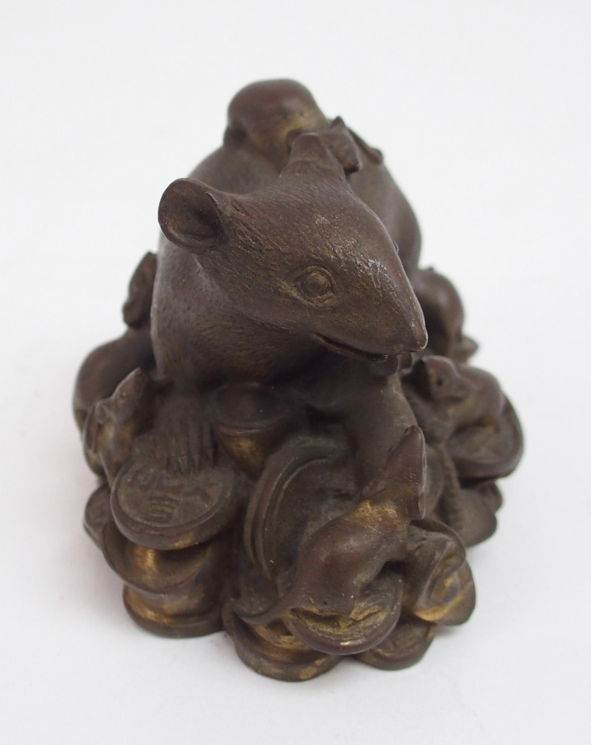A CHINESE BRONZE FIGURE OF A RECUMBENT RAT modelled seated on a pile of archaic coins, surrounded by - Image 4 of 5