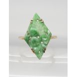 A CHINESE GREEN HARDSTONE RING set with a lozenge shaped plaque, carved with fruit. In a 9ct gold