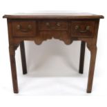 A GEORGIAN MAHOGANY LOWBOY with central shallow drawer flanked by deep drawers either side over