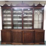 A 19TH CENTURY MAHOGANY BREAKFRONT LIBRARY BOOKCASE with moulded serpentine cornice topped with