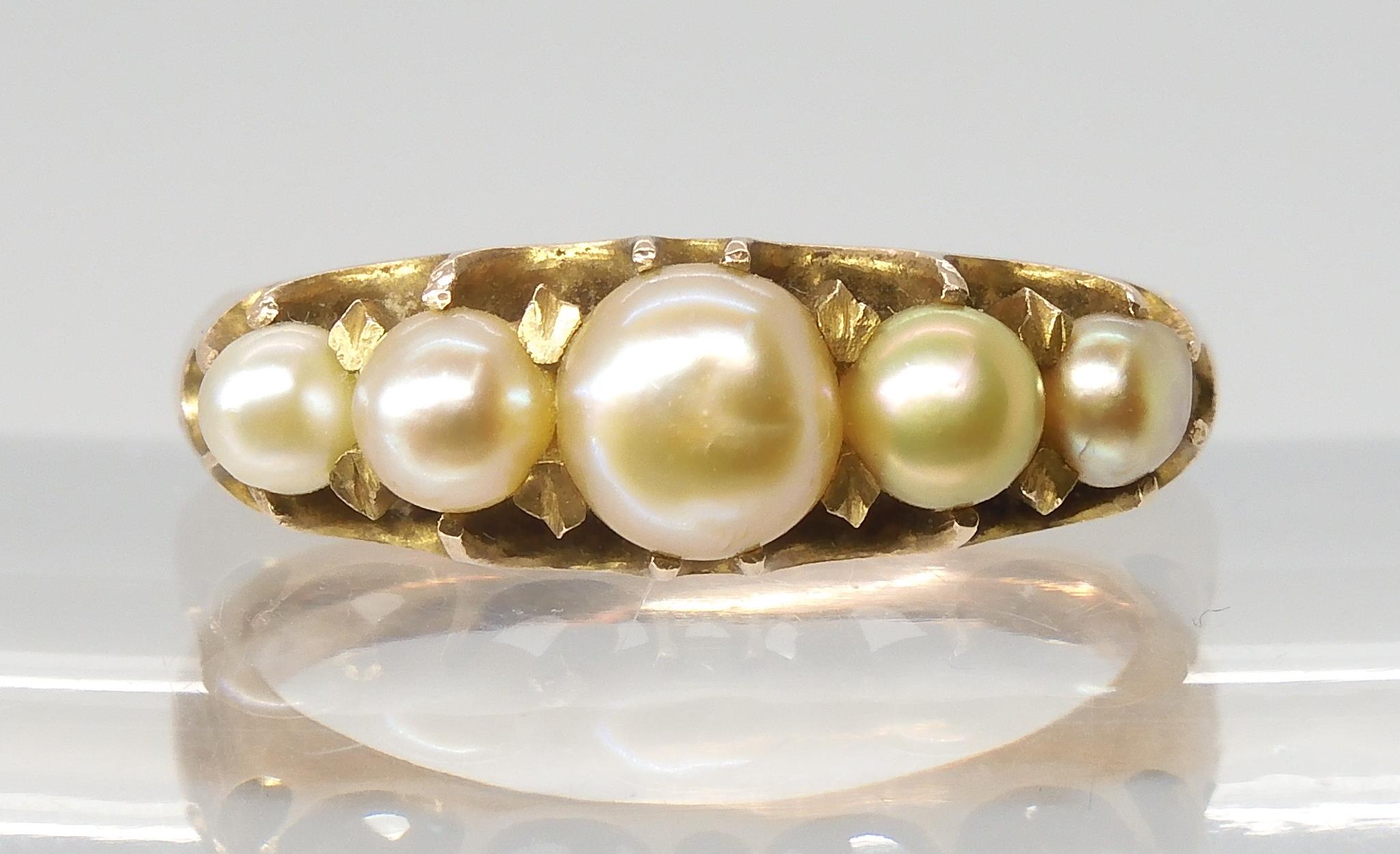 A VINTAGE PEARL RING set with five freeform cream pearls with good lustre, in a yellow metal