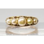 A VINTAGE PEARL RING set with five freeform cream pearls with good lustre, in a yellow metal