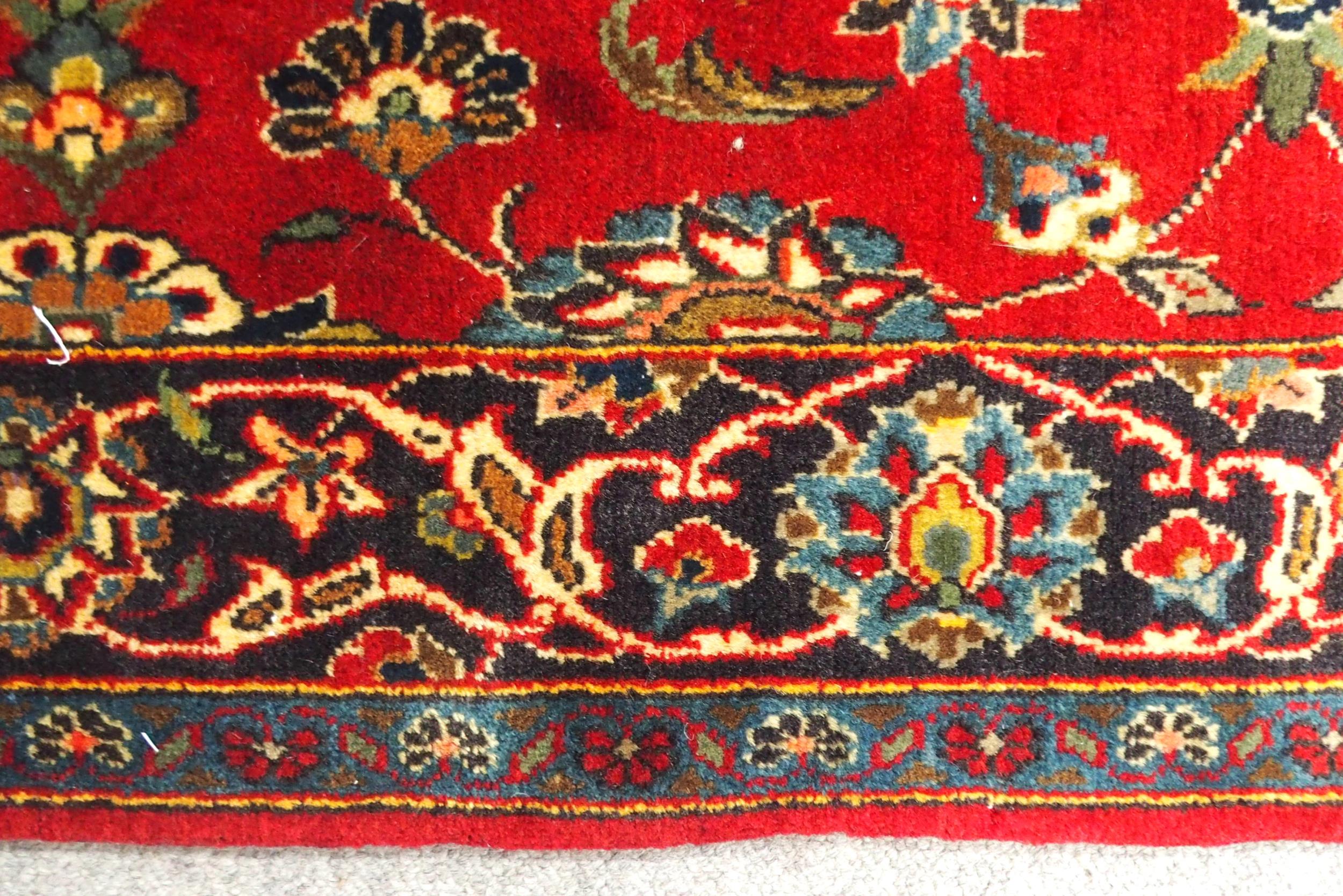 A RED GROUND TABRIZ RUG with all-over floral design and dark blue flower head border, 166cm long x - Image 7 of 7