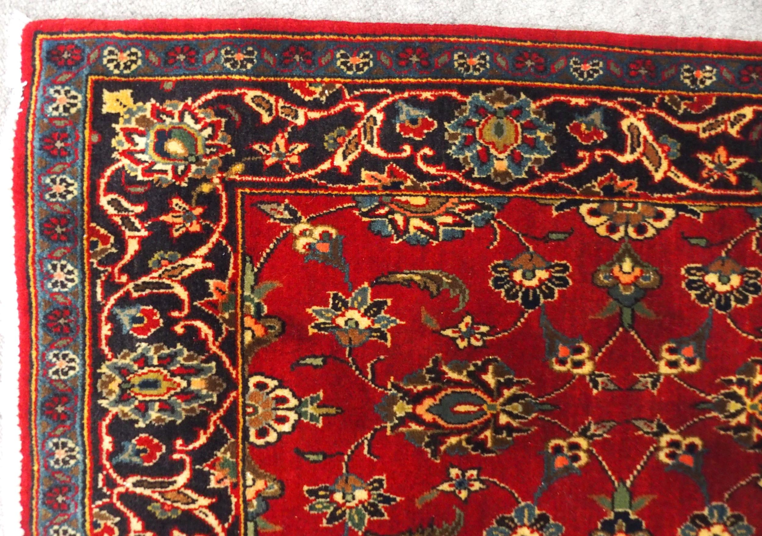 A RED GROUND TABRIZ RUG with all-over floral design and dark blue flower head border, 166cm long x - Image 3 of 7