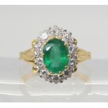 AN EMERALD & DIAMOND CLUSTER RING set throughout in 18ct yellow and white gold, with fleur de lys