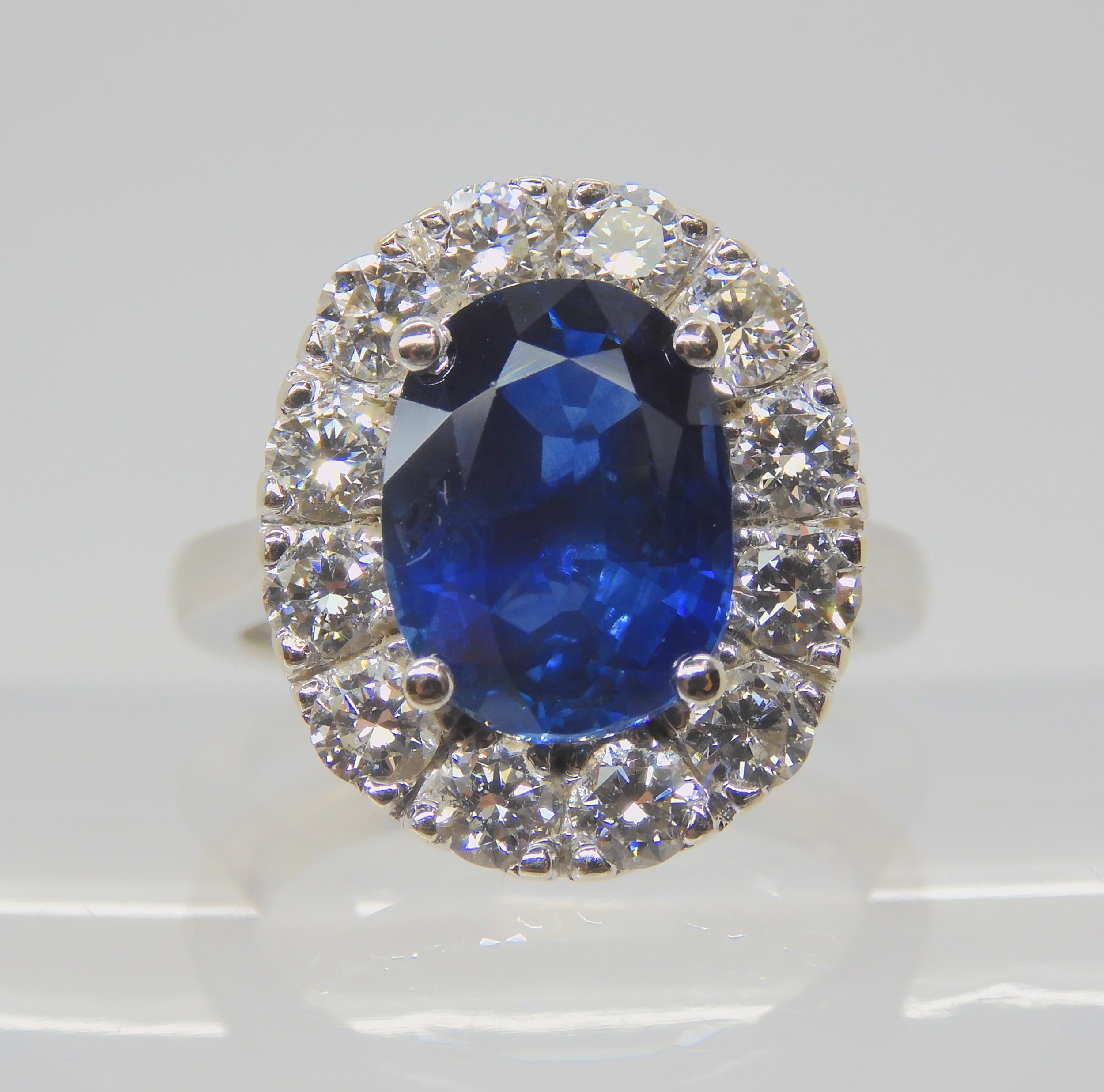 A SAPPHIRE AND DIAMOND CLUSTER RING set throughout in 18ct white gold, set with an oval mixed cut - Image 3 of 9