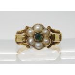 A VICTORIAN FLOWER RING mounted in bright yellow metal set with split pearls and a green gem, finger