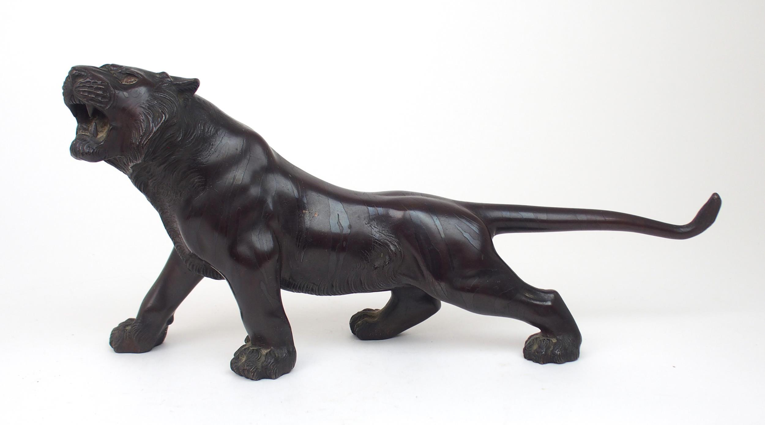 A JAPANESE BRONZE MODEL OF A TIGER  the animal with head raised and standing on all fours, signed,