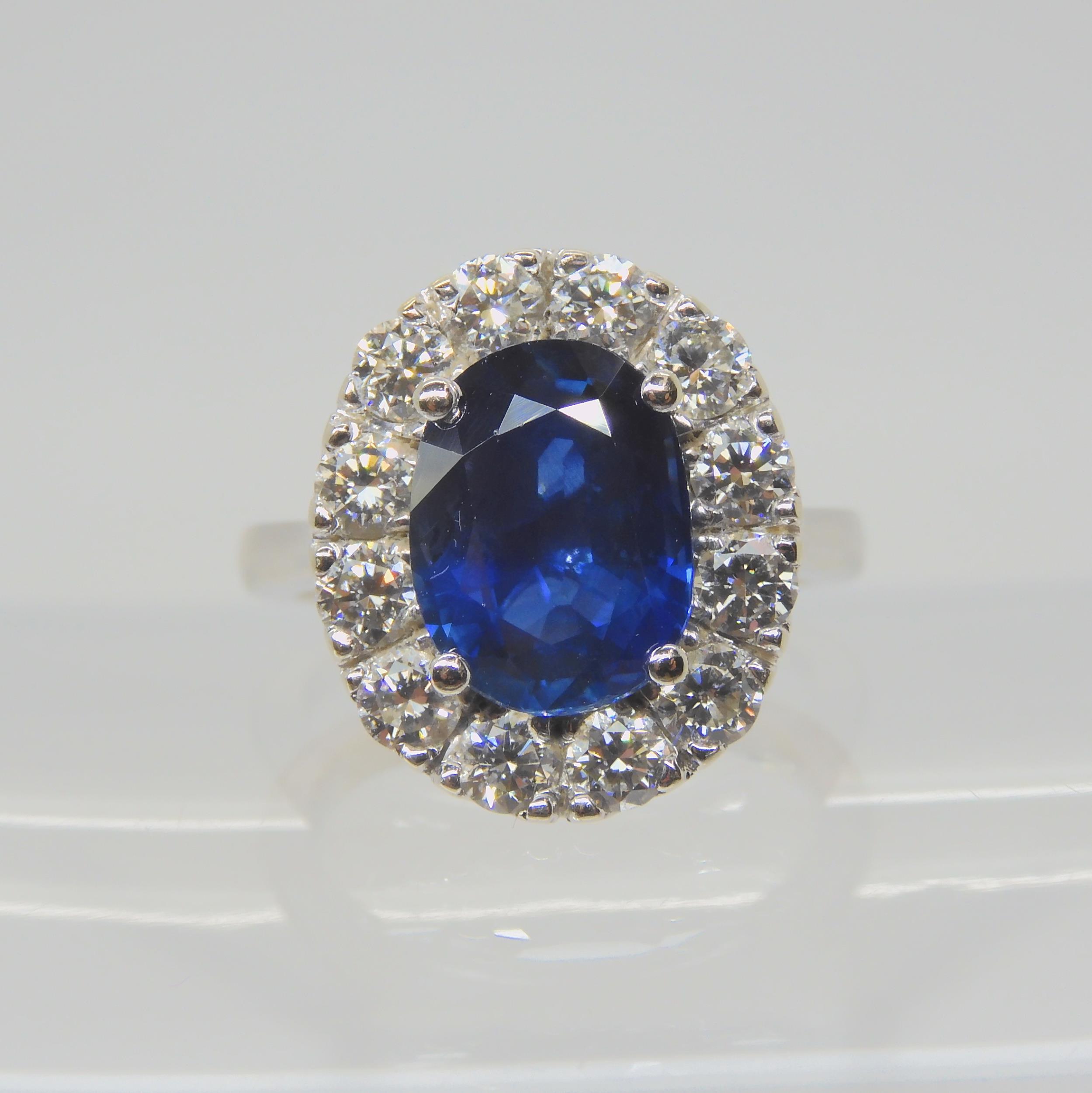 A SAPPHIRE AND DIAMOND CLUSTER RING set throughout in 18ct white gold, set with an oval mixed cut - Image 4 of 9