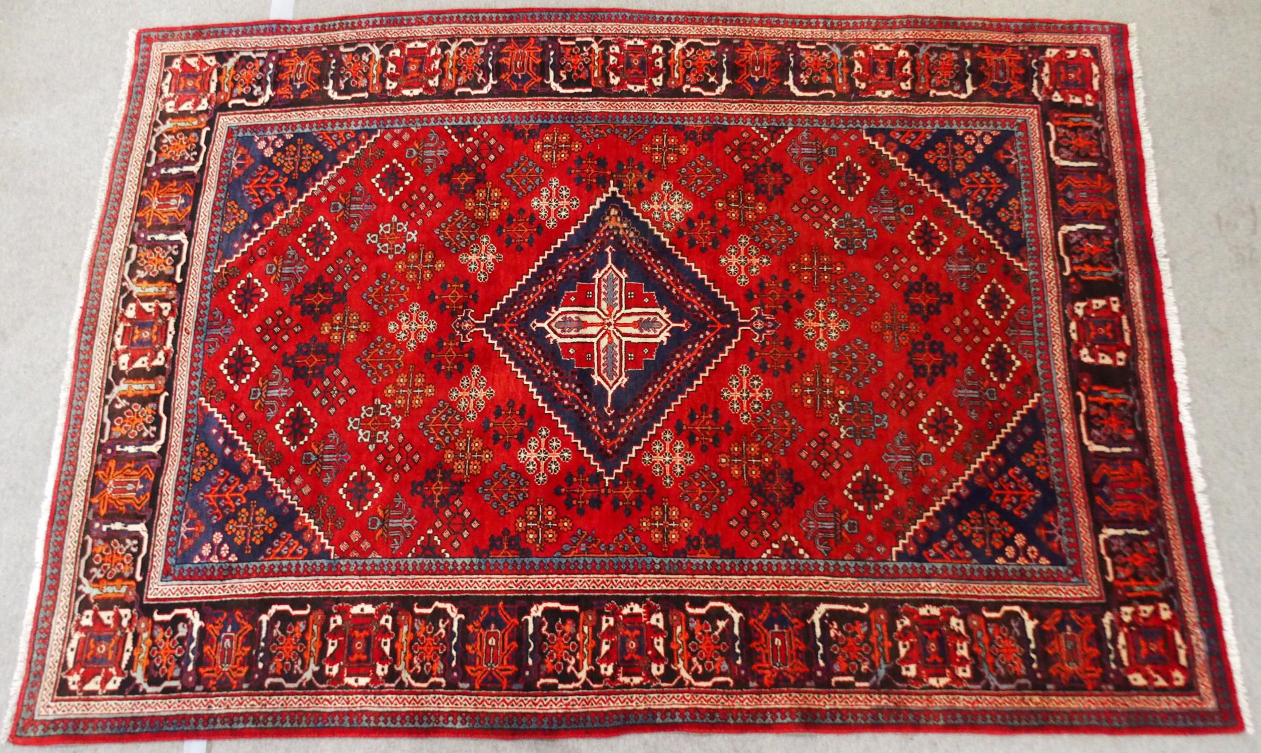 A RED GROUND MEIMEH RUG with dark blue central medallion, matching spandrels and dark blue flower