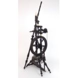 A CONTINENTAL EBONISED SPINNING WHEEL OF SMALL PROPORTIONS  Ornately turned, with decorative