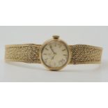 A 9CT GOLD LADIES OMEGA with integral textured strap, cream dial with gold coloured baton