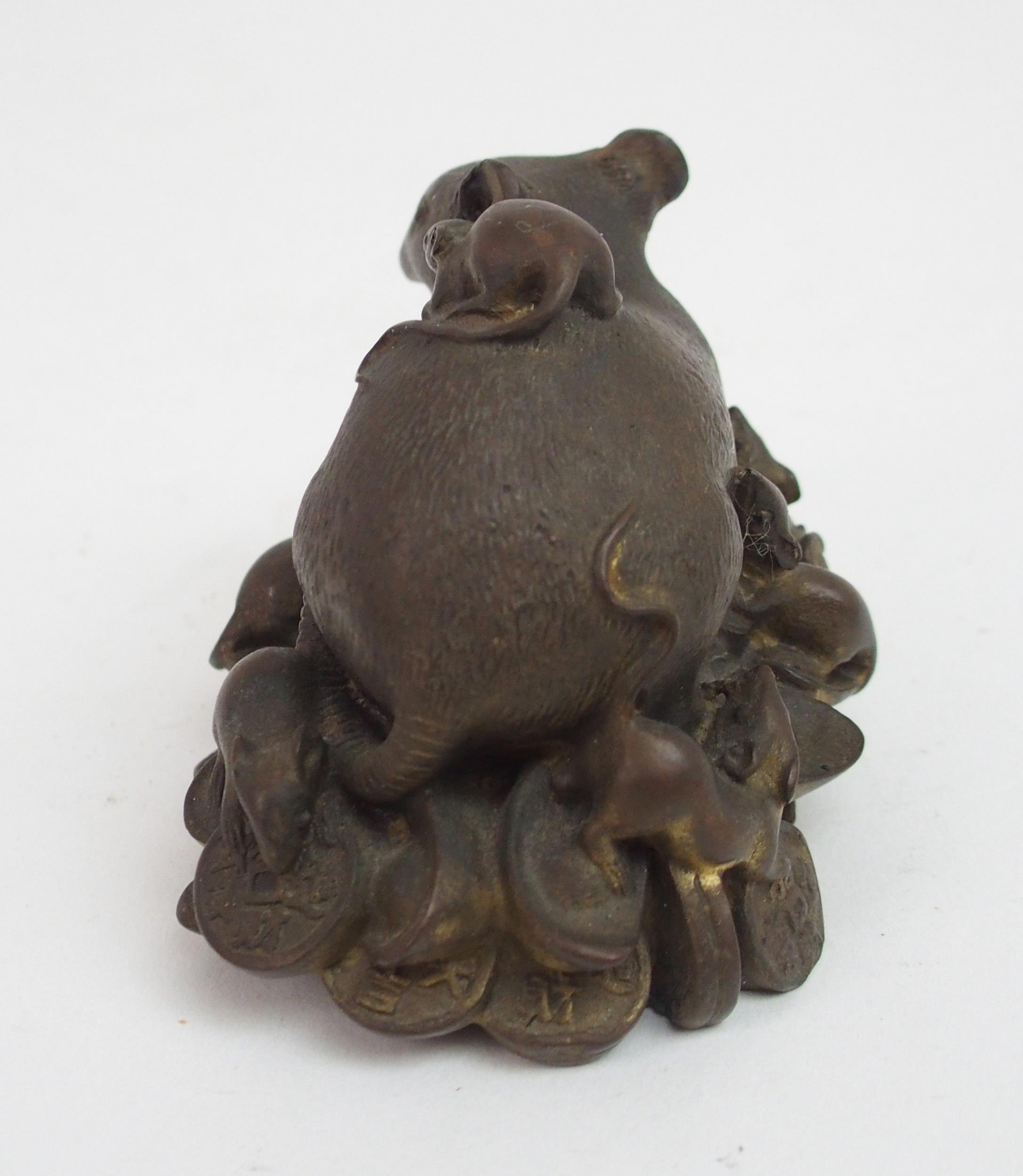 A CHINESE BRONZE FIGURE OF A RECUMBENT RAT modelled seated on a pile of archaic coins, surrounded by - Image 2 of 5