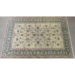 A CREAM GROUND KASHAN RUG with all-over floral design and flower head border, 361cm long x 242cm
