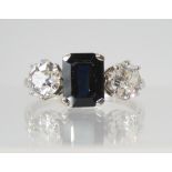 A SAPPHIRE AND DIAMOND THREE STONE RING set throughout in white metal, the two diamonds have an