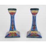 A PAIR OF GEORGE CARTLIDGE FOR MORRISWARE CANDLESTICKS with tube lined stylised decoration of seed