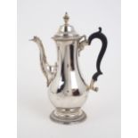 A GEORGE III SILVER COFFEE POT of baluster form, with a beaded knop finial and a domed lid and