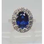 A SAPPHIRE AND DIAMOND CLUSTER RING set throughout in 18ct white gold, set with an oval mixed cut