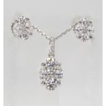 A DIAMOND PENDANT AND EARRING SET An 18ct white gold diamond set pendant set with brilliant cuts,