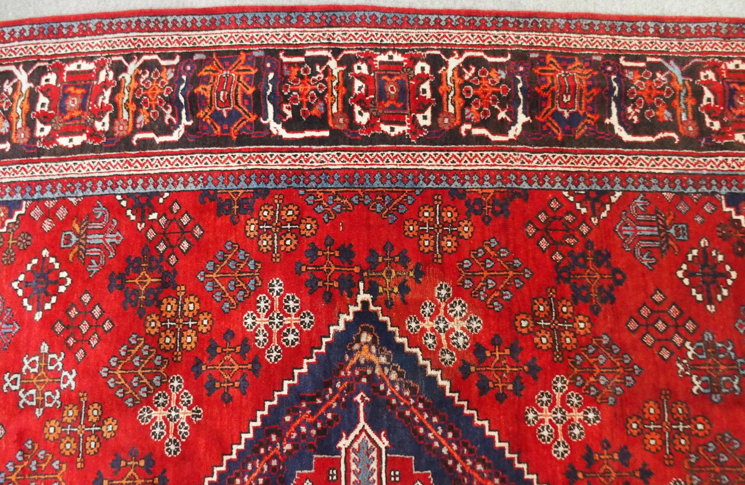 A RED GROUND MEIMEH RUG with dark blue central medallion, matching spandrels and dark blue flower - Image 5 of 10