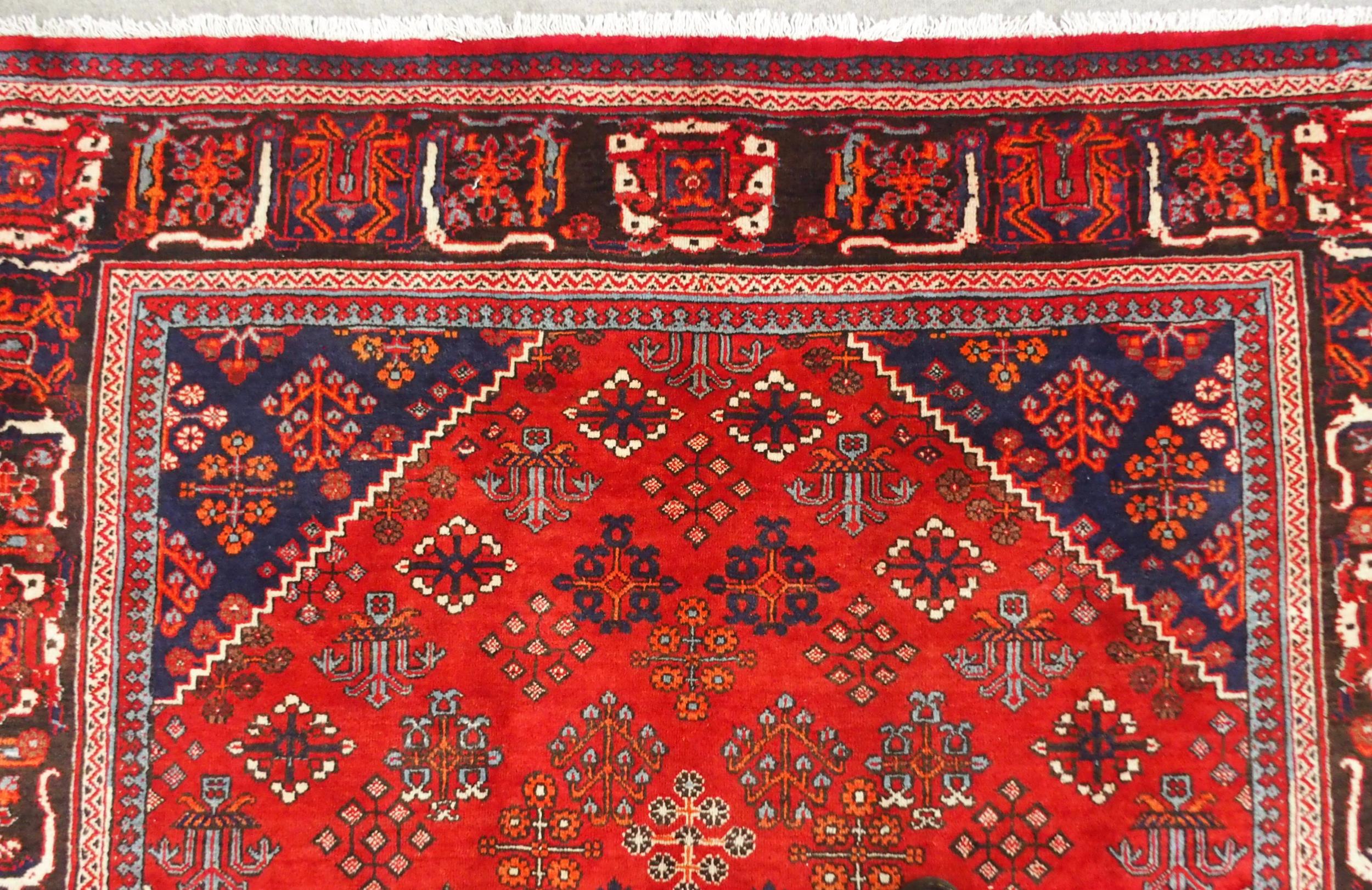 A RED GROUND MEIMEH RUG with dark blue central medallion, matching spandrels and dark blue flower - Image 4 of 10