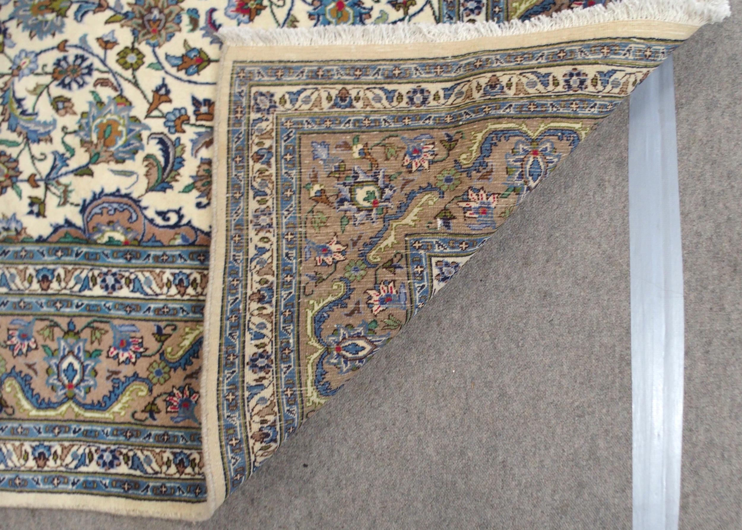 A CREAM GROUND MESHED RUG with multicolour flower head central medallion, matching spandrels and - Bild 8 aus 10