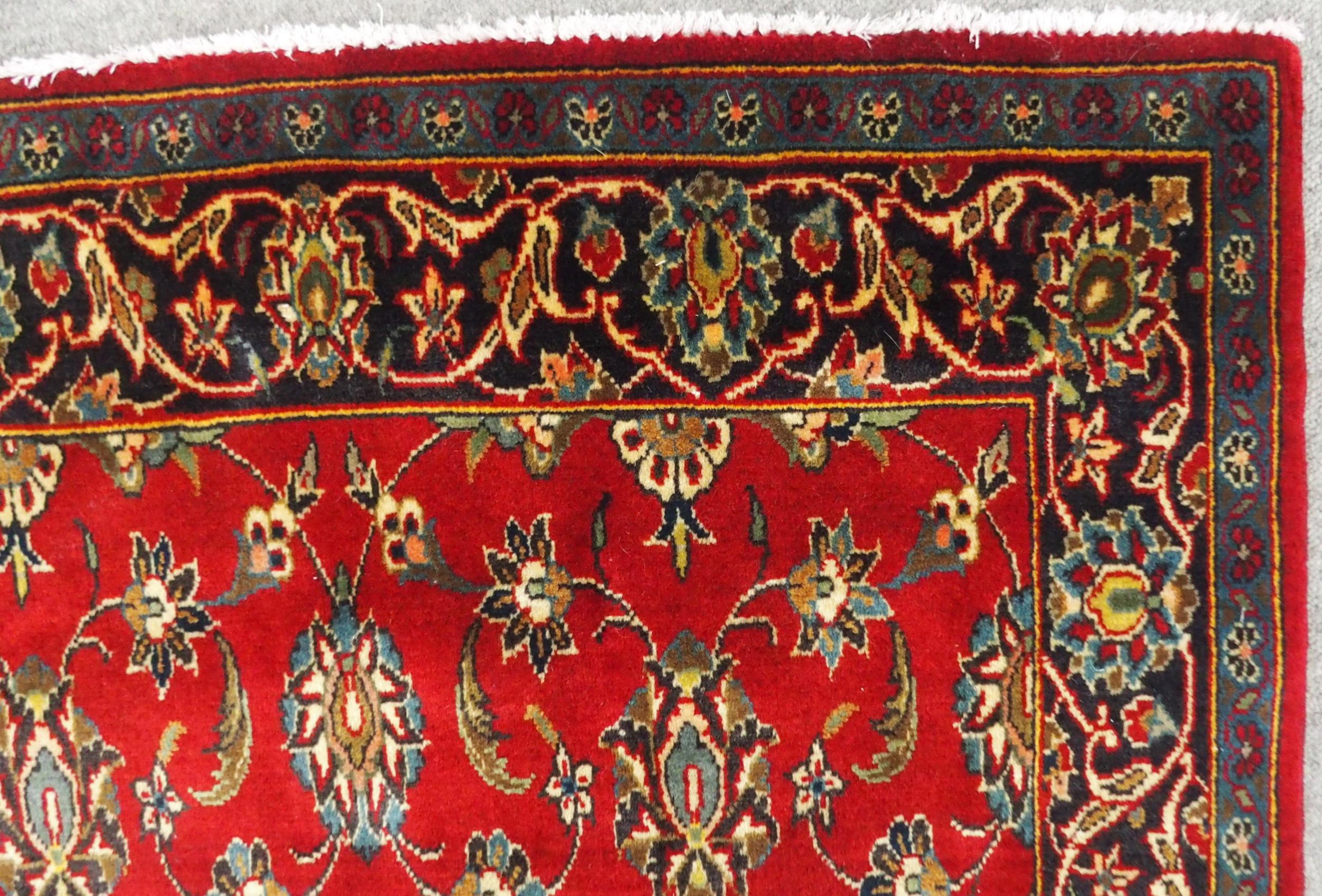 A RED GROUND TABRIZ RUG with all-over floral design and dark blue flower head border, 166cm long x - Image 5 of 7