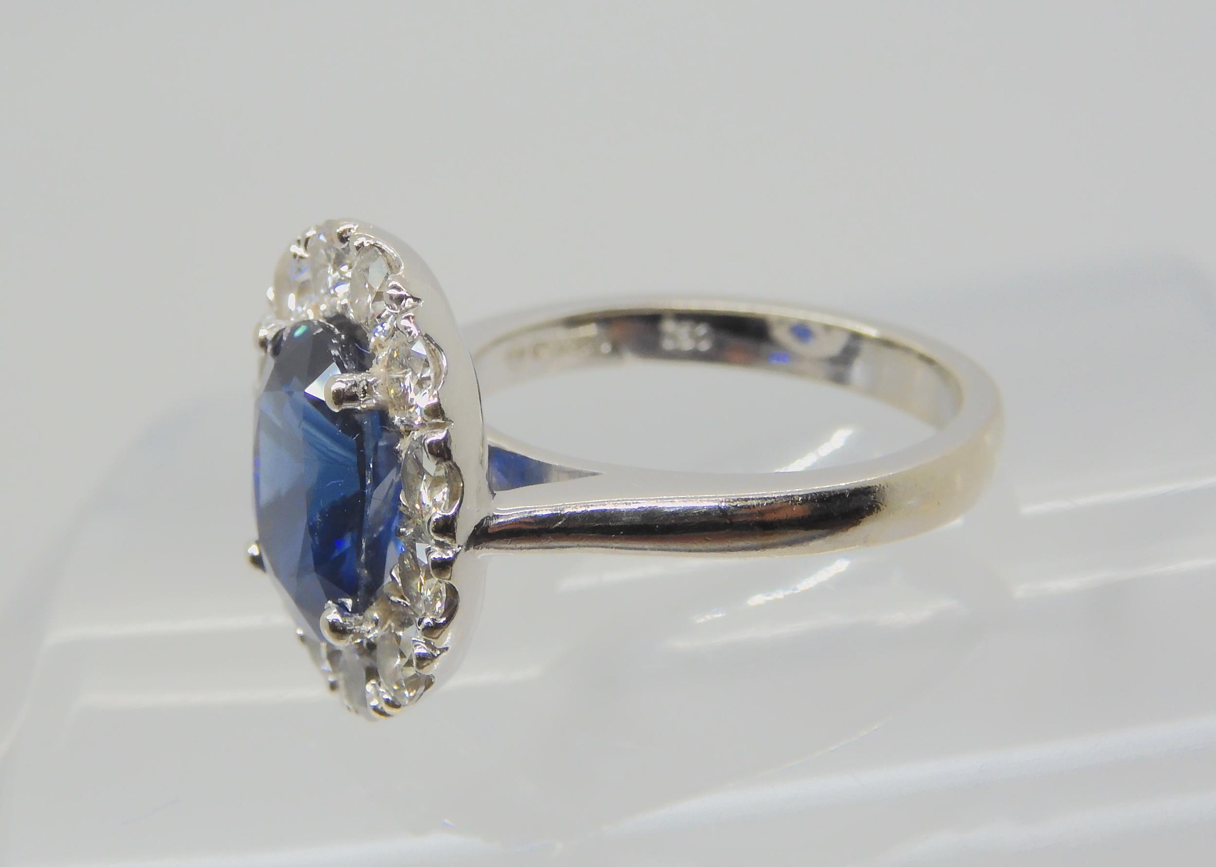 A SAPPHIRE AND DIAMOND CLUSTER RING set throughout in 18ct white gold, set with an oval mixed cut - Image 7 of 9