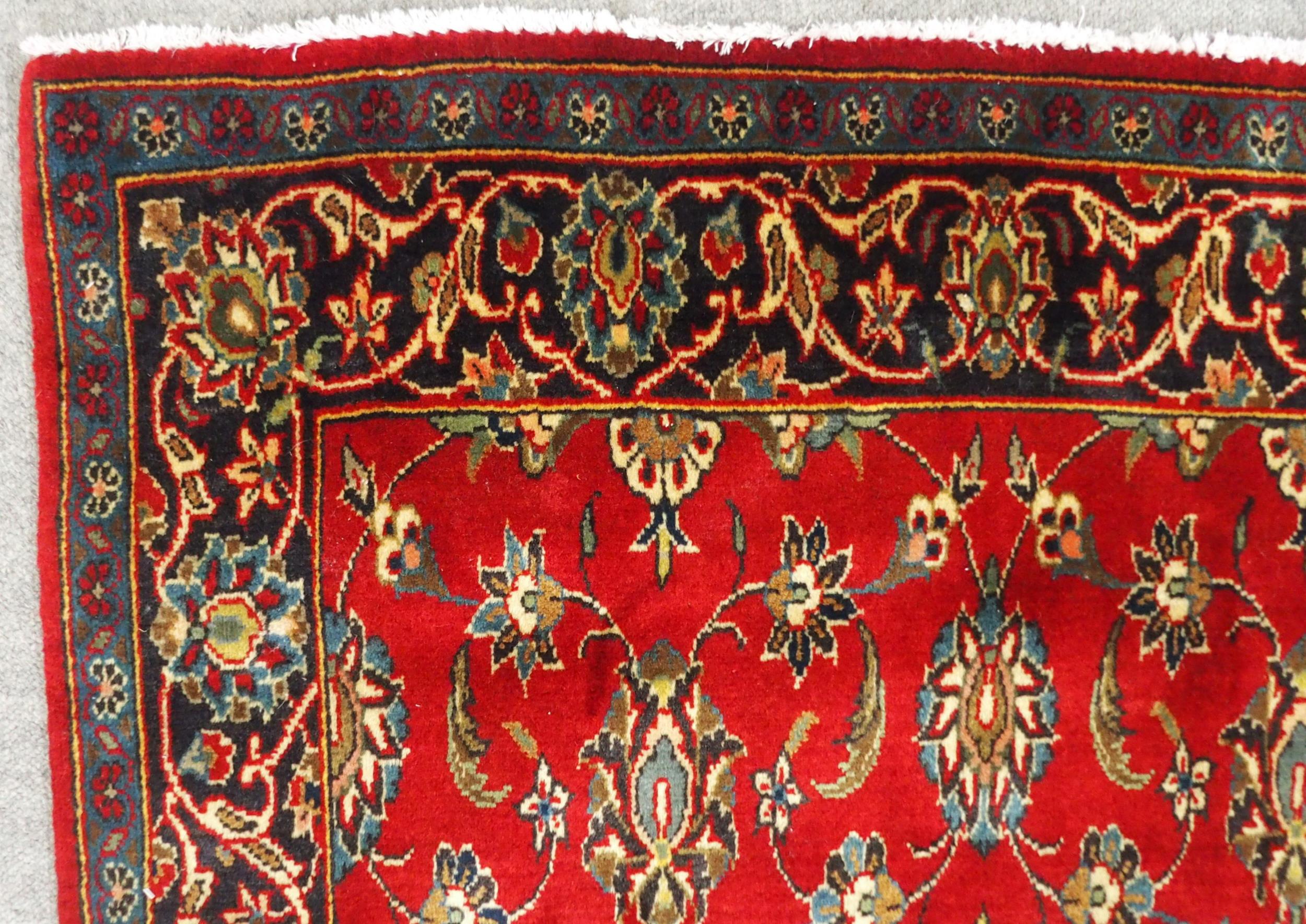 A RED GROUND TABRIZ RUG with all-over floral design and dark blue flower head border, 166cm long x - Image 4 of 7