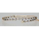 A VINTAGE DIAMOND AND PEARL BANGLE set with 1.40cts of old cut diamonds, largest diamond approx 0.