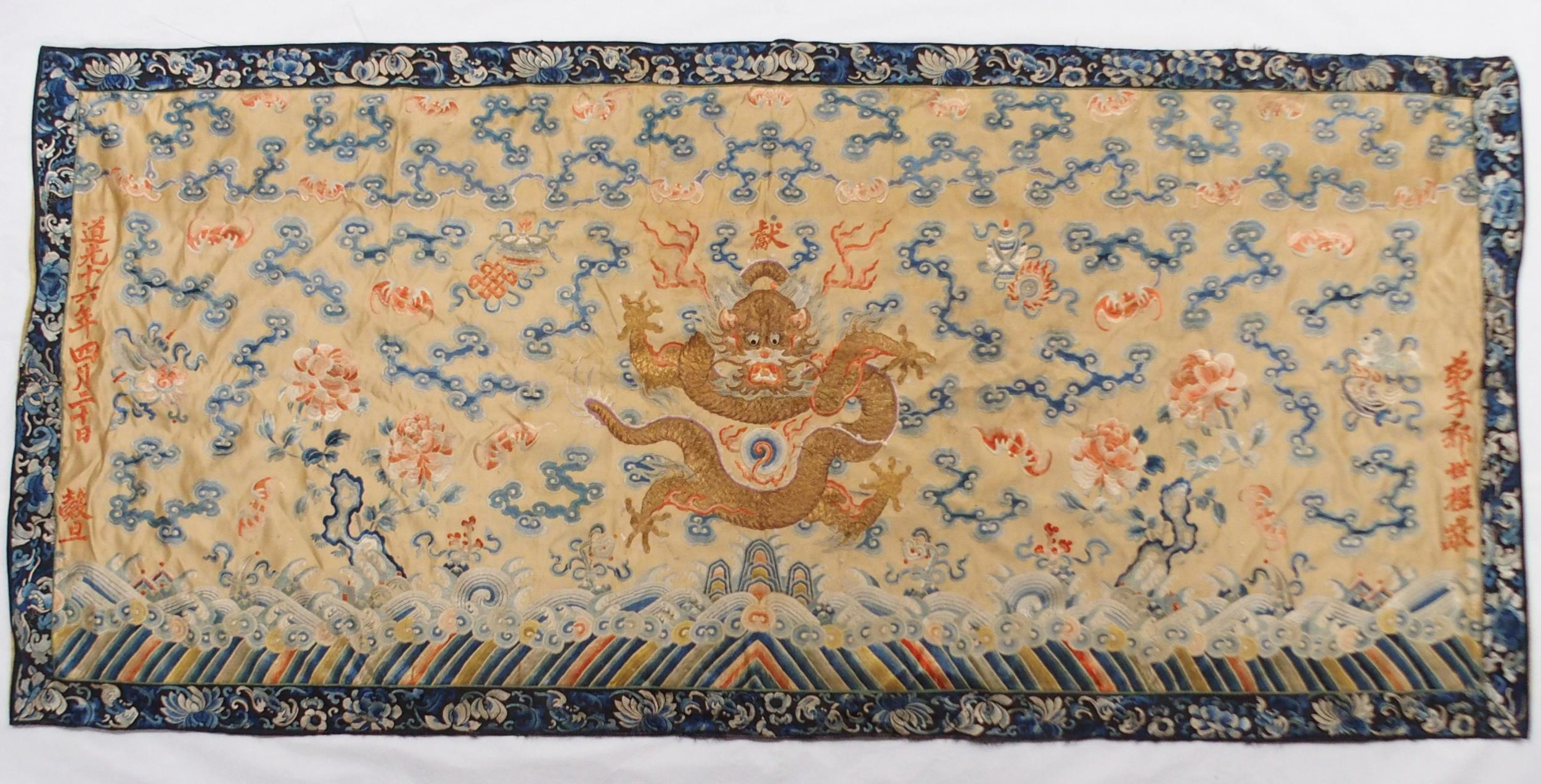 A CHINESE SILK PANEL decorated in coloured threads on a cream ground within a blue and white