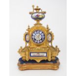 A 19TH CENTURY FRENCH ORMOLU MANTEL CLOCK with porcelain dial, panels and finial, painted with