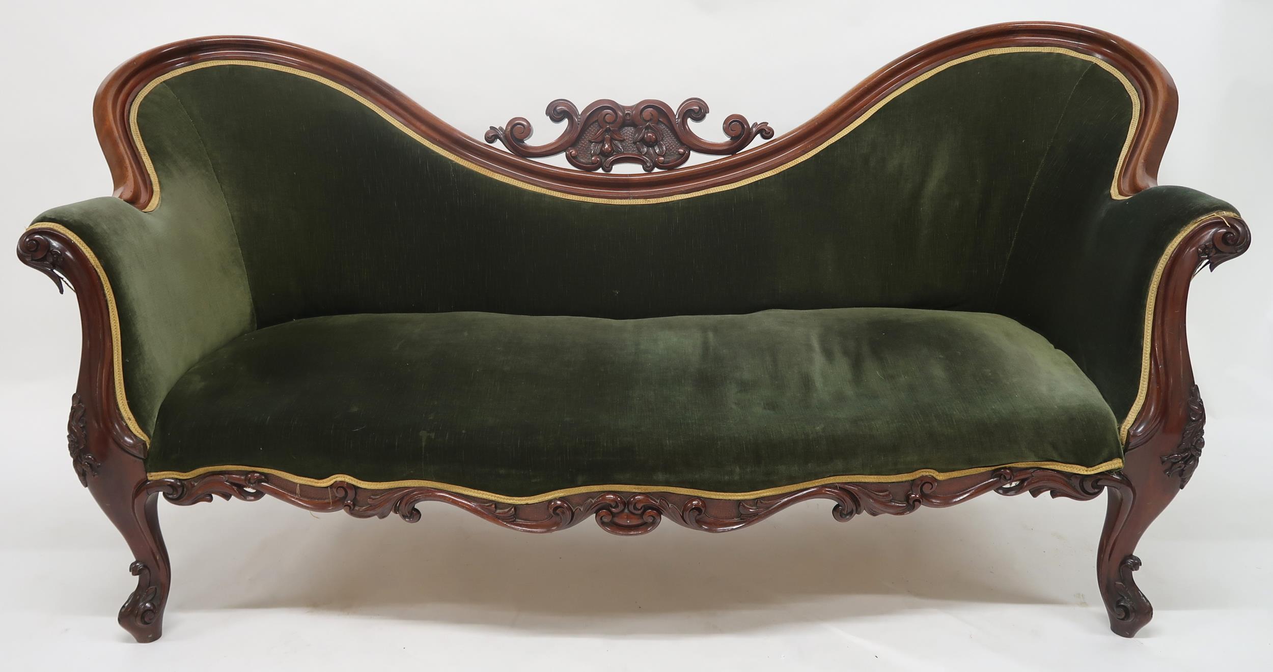 A VICTORIAN WALNUT FRAMED TWIN SPOONBACK SALON SETTEE with carved scrolled surmount over velour