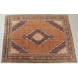A COPPER GROUND TABRIZ GROUND RUG with multicoloured central medallion, matching spandrels and