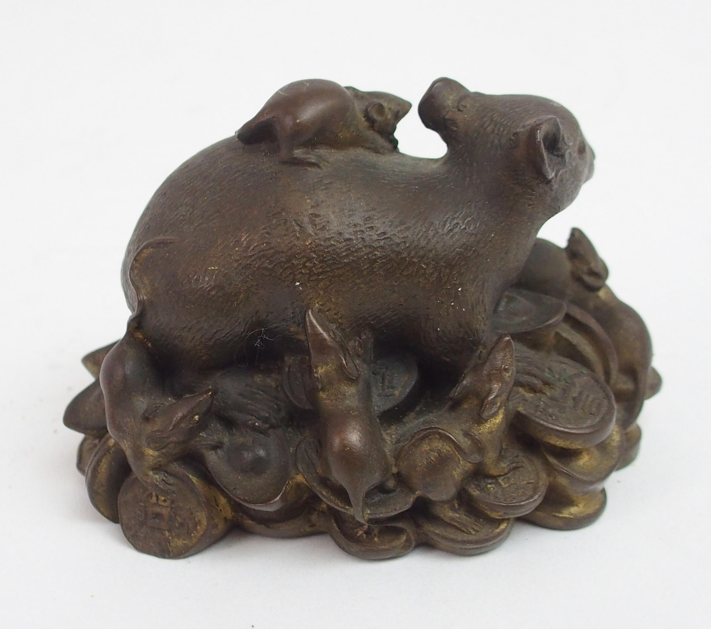 A CHINESE BRONZE FIGURE OF A RECUMBENT RAT modelled seated on a pile of archaic coins, surrounded by - Image 3 of 5