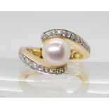 A DIAMOND AND PEARL RING mounted in 18ct yellow gold the 7.6mm pearl is flanked with two rows of