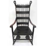 A 19TH CENTURY CONTINENTAL ROCKING CHAIR with carved slated back interspaced with turned bobbins