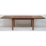 A MID 20TH CENTURY TEAK EXTENDING DINING TABLE with rectangular top concealing three internal leaves