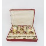 A ROYAL WORCESTER BOXED SET OF SIX DEMITASSE COFFEE CUPS AND SAUCERS each painted with roses in a