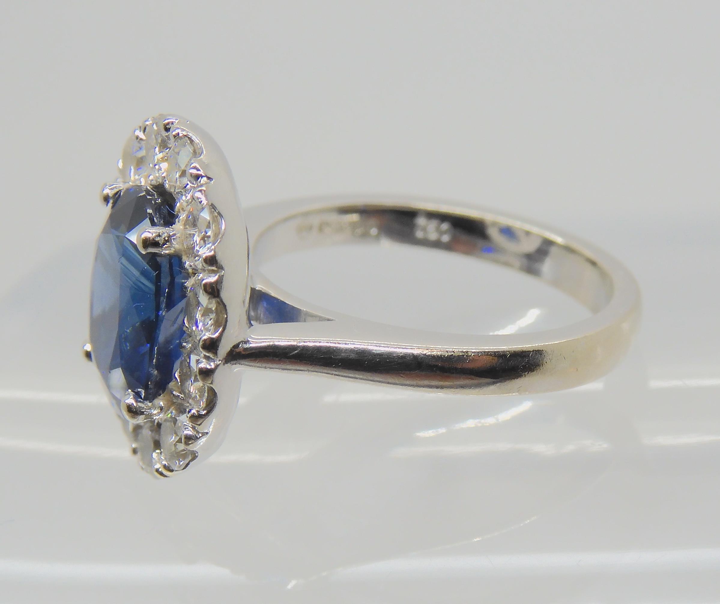 A SAPPHIRE AND DIAMOND CLUSTER RING set throughout in 18ct white gold, set with an oval mixed cut - Image 8 of 9