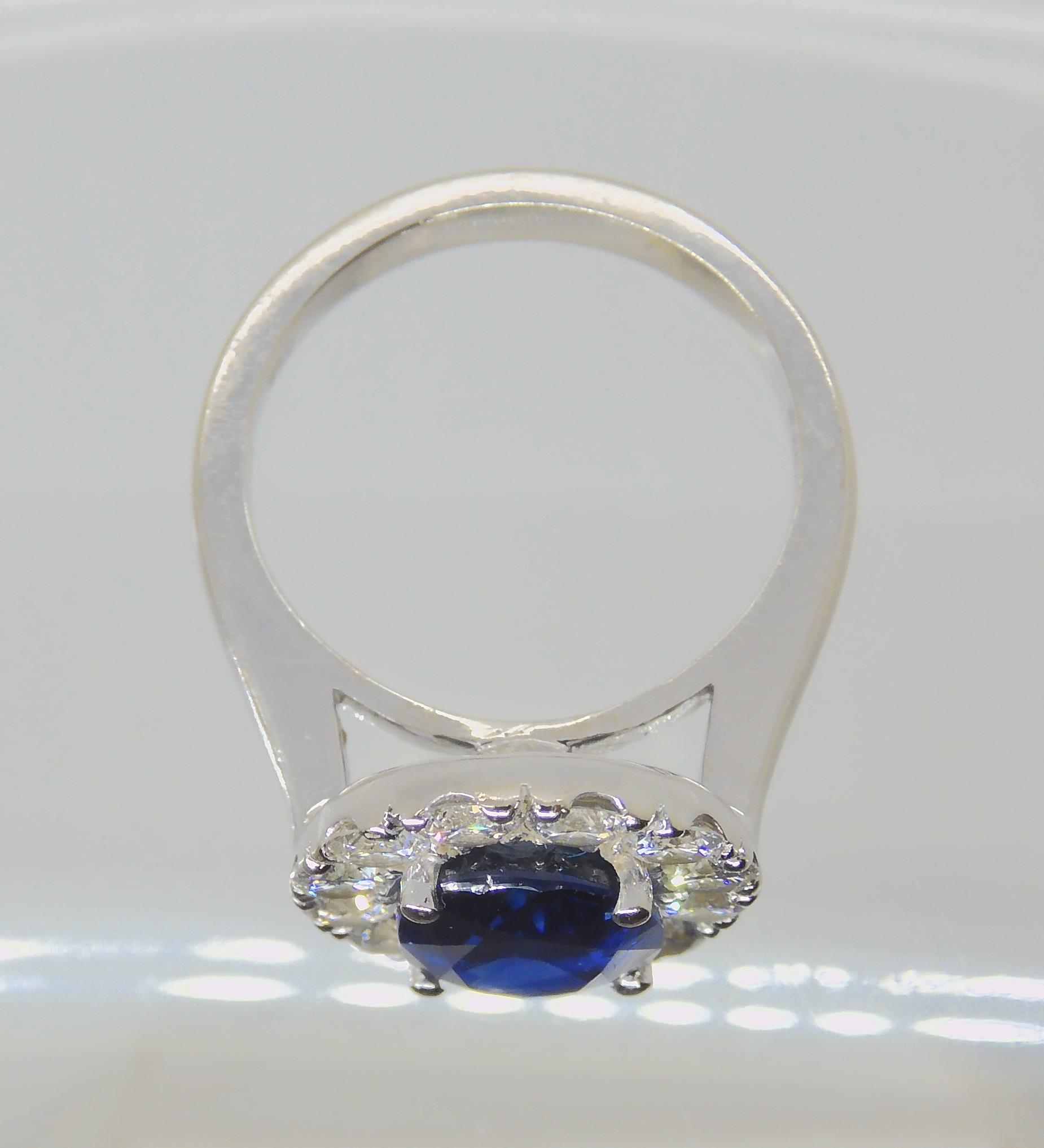 A SAPPHIRE AND DIAMOND CLUSTER RING set throughout in 18ct white gold, set with an oval mixed cut - Image 6 of 9