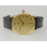 AN 18CT GOLD BAUME & MERCIER BAUMATIC gents watch, with oval gold coloured dial, black hands and