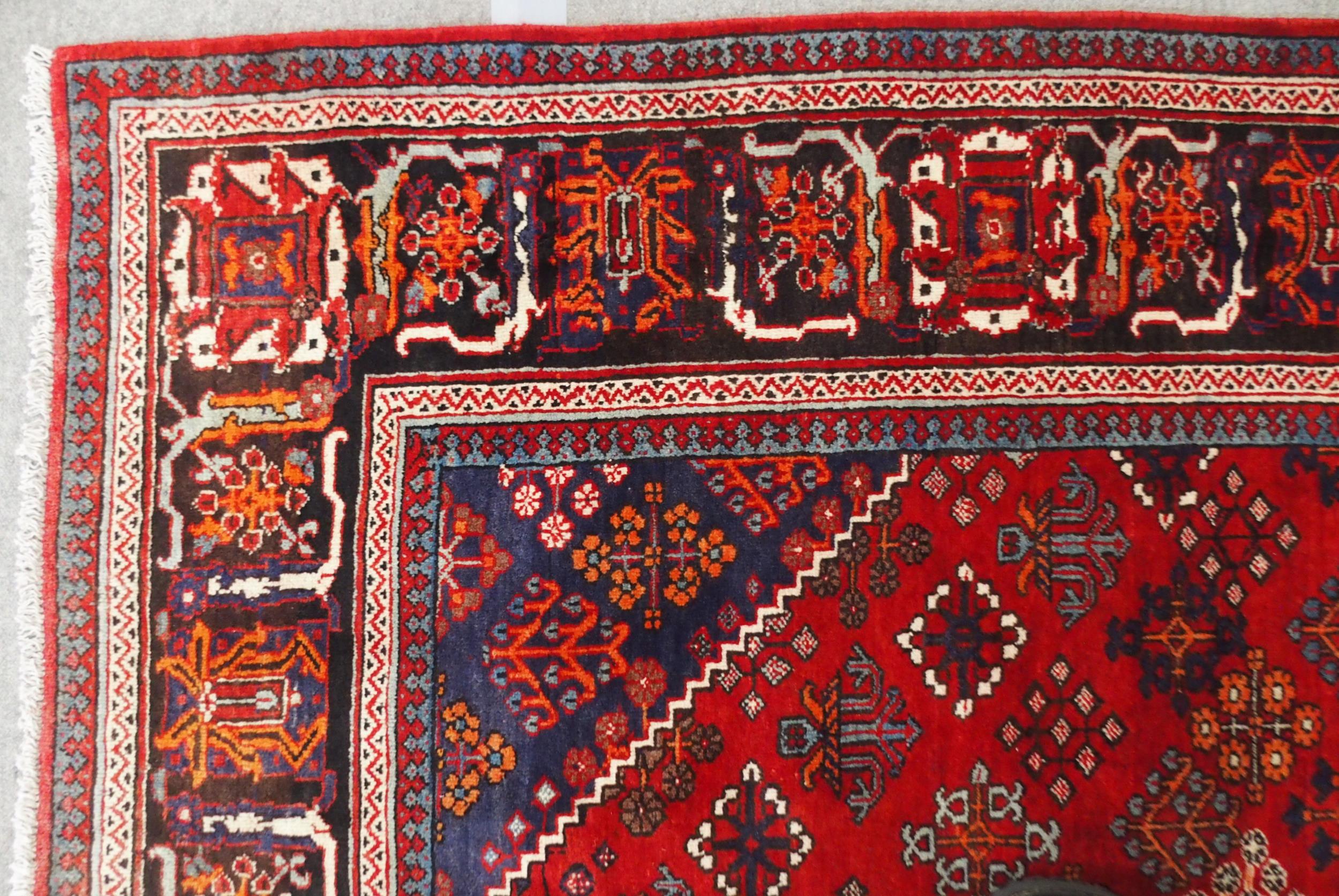 A RED GROUND MEIMEH RUG with dark blue central medallion, matching spandrels and dark blue flower - Image 6 of 10