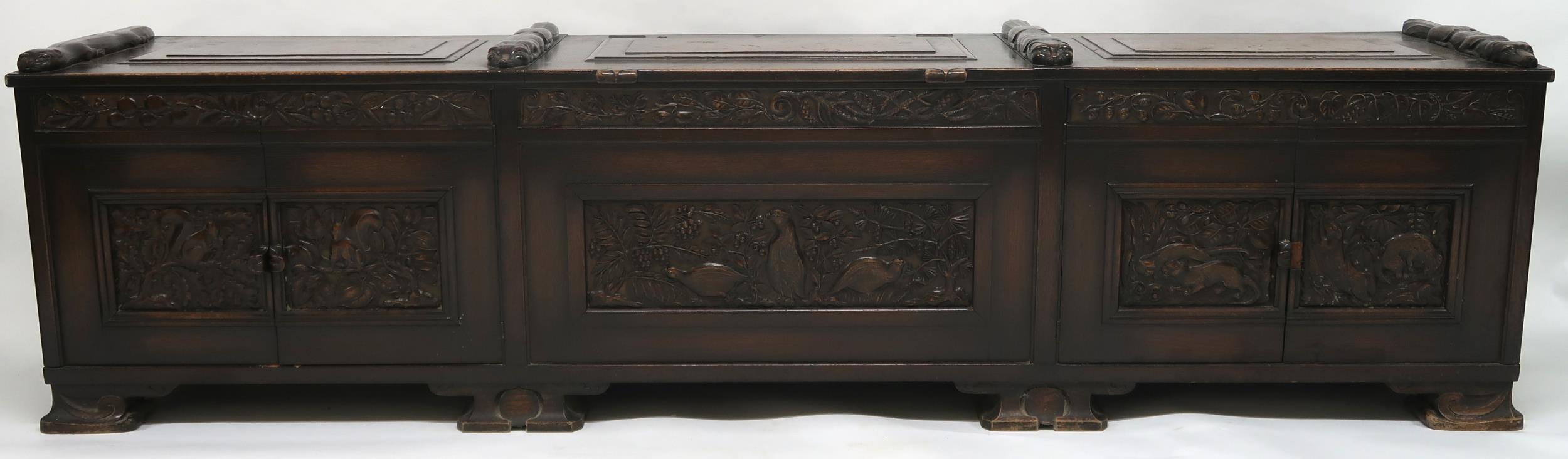 AN ARTS AND CRAFTS OAK AND BURR WALNUT COFFER the three section hinged top carved with foxes and